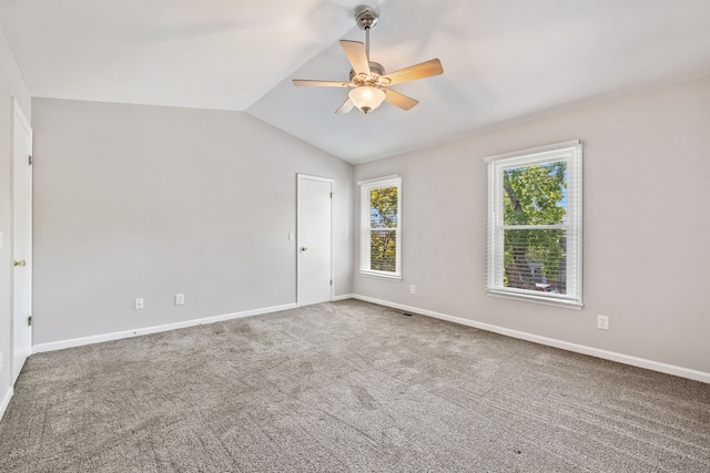 unfurnished room featuring ceiling fan, vaulted ceiling, and carpet