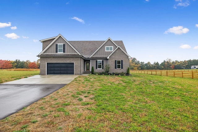 view of front facade with a front lawn, a garage, and a rural view