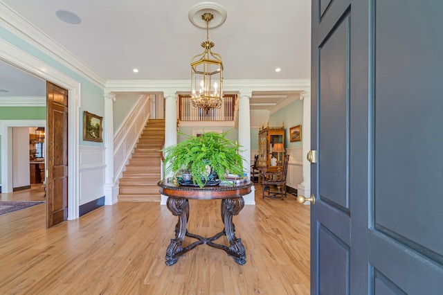 entryway featuring ornate columns, crown molding, and light hardwood / wood-style floors