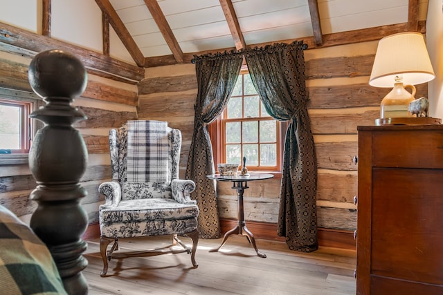 sitting room featuring light wood-type flooring and lofted ceiling with beams