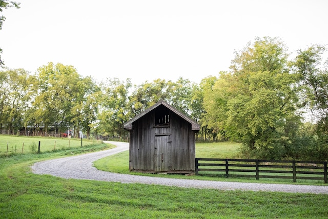 view of outbuilding with a rural view and a yard