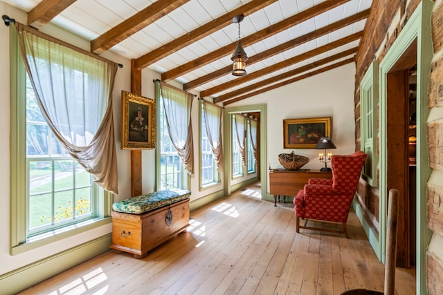 living area with vaulted ceiling with beams and light hardwood / wood-style floors