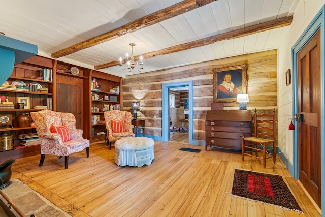 living area with beamed ceiling, wooden walls, light wood-type flooring, and a notable chandelier