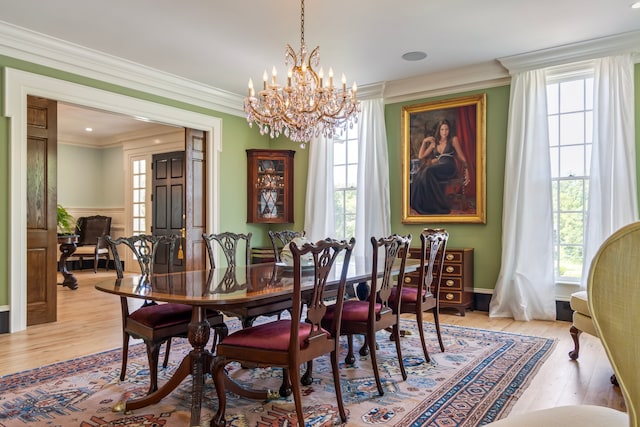 dining space featuring a notable chandelier, light wood-type flooring, and ornamental molding