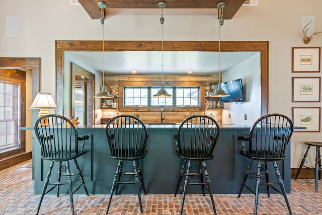 kitchen with a kitchen bar, decorative light fixtures, and a healthy amount of sunlight