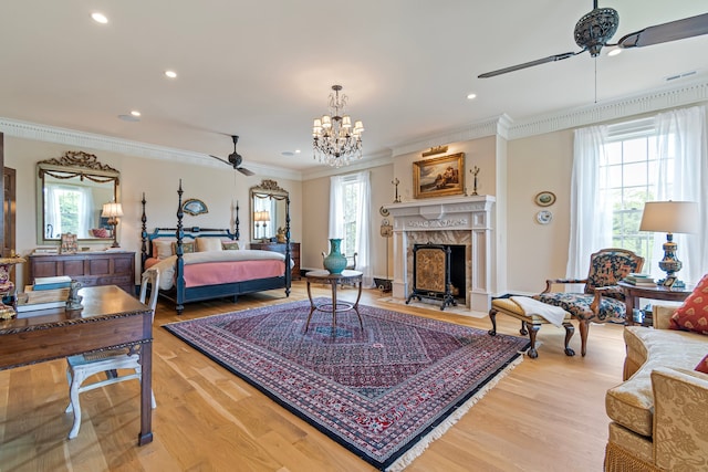 bedroom with light hardwood / wood-style floors, a fireplace, ornamental molding, and multiple windows