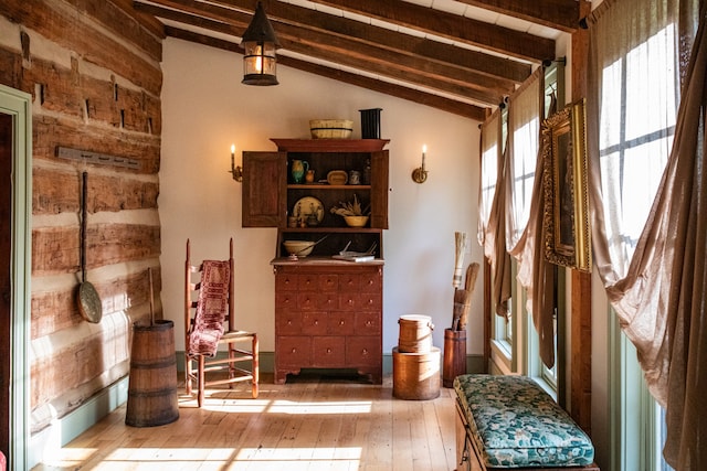 living area with lofted ceiling with beams and light hardwood / wood-style floors