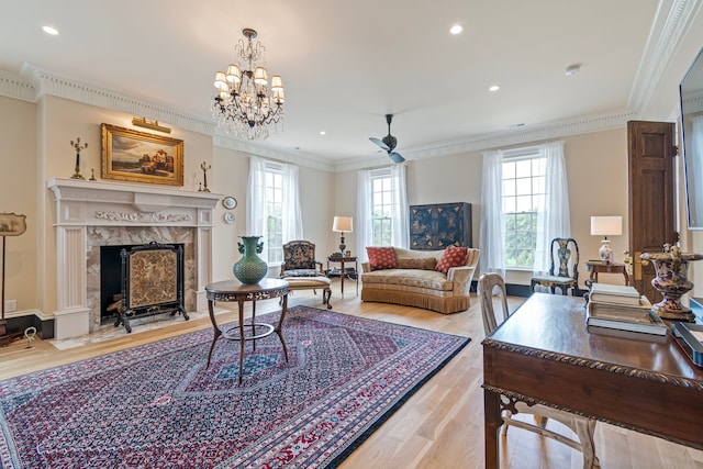 living room with a fireplace, a wealth of natural light, an inviting chandelier, and light hardwood / wood-style floors