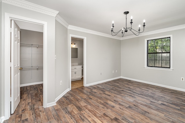 interior space with ensuite bath, crown molding, an inviting chandelier, dark hardwood / wood-style floors, and a closet