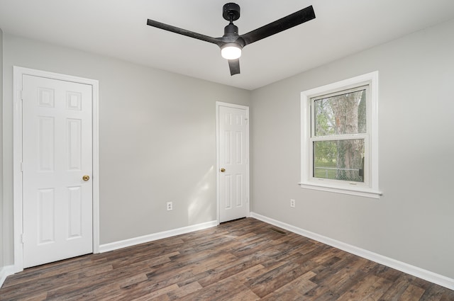 unfurnished bedroom featuring dark hardwood / wood-style floors and ceiling fan