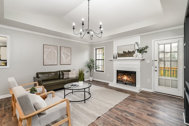 living room with lofted ceiling, dark hardwood / wood-style floors, an inviting chandelier, and crown molding