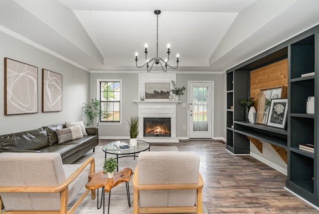 living room featuring an inviting chandelier, a raised ceiling, crown molding, wood-type flooring, and lofted ceiling