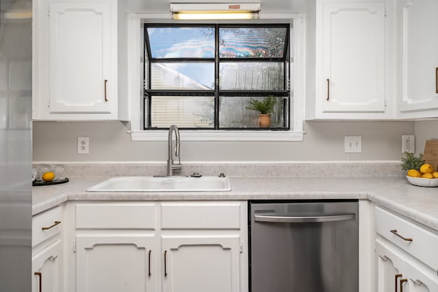 kitchen with stainless steel dishwasher, white cabinetry, and sink