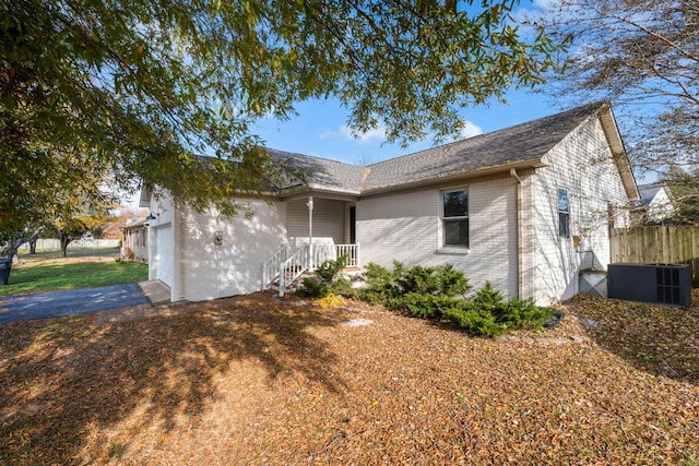 single story home featuring cooling unit and a garage