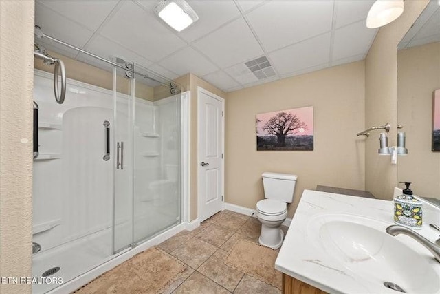 bathroom featuring a stall shower, visible vents, a drop ceiling, toilet, and vanity