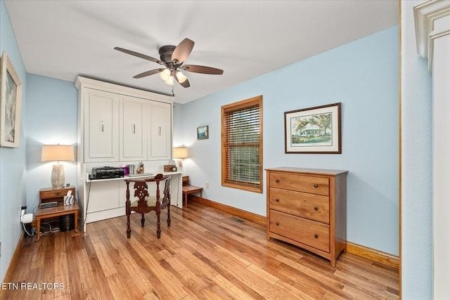 office area with baseboards, ceiling fan, and light wood finished floors