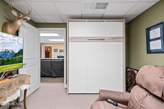 interior space with a paneled ceiling, visible vents, and light colored carpet