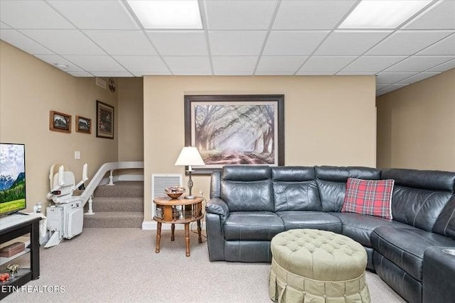 carpeted living room featuring a drop ceiling, visible vents, and stairs