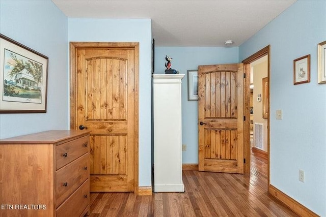 interior space with visible vents, baseboards, and wood finished floors