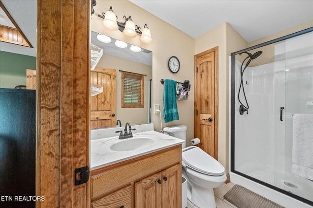 full bathroom with toilet, vanity, a shower stall, and tile patterned floors