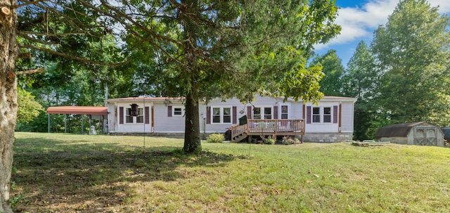 back of property featuring a wooden deck, a yard, and a storage unit