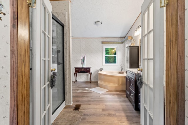 bathroom featuring hardwood / wood-style floors, independent shower and bath, and a textured ceiling