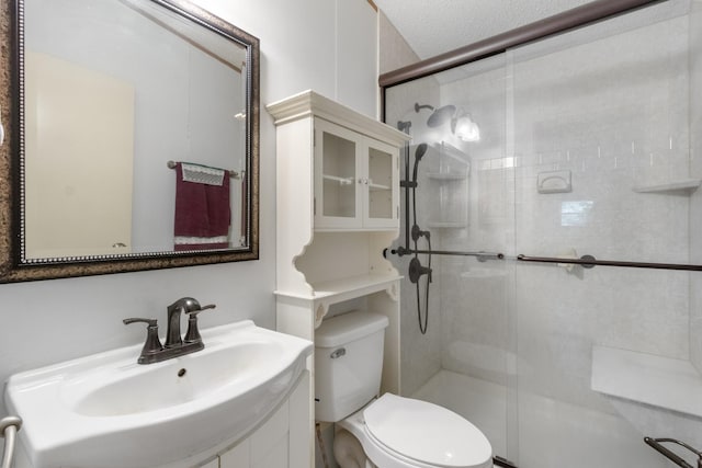 bathroom with sink, a shower with door, and toilet