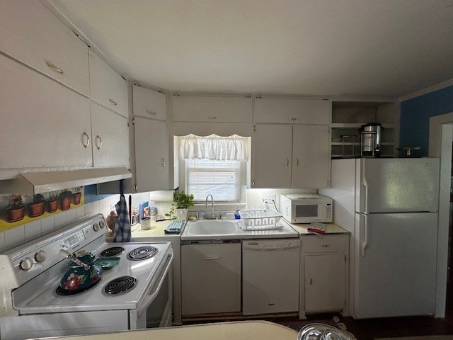 kitchen with white appliances, exhaust hood, backsplash, sink, and white cabinets