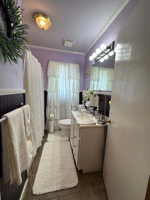 bathroom featuring tile patterned flooring, vanity, toilet, and crown molding