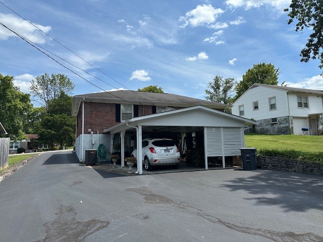 view of side of property featuring a lawn and a carport