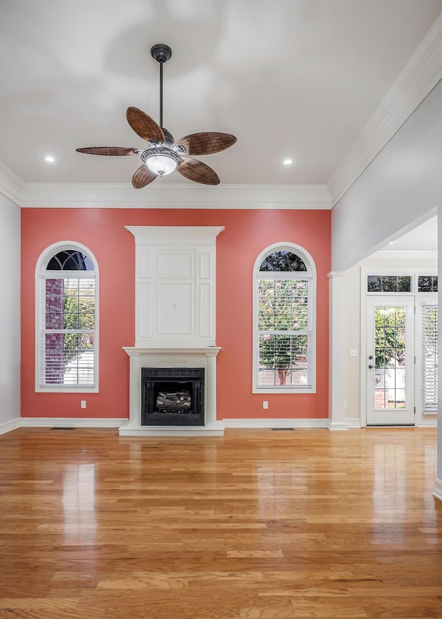 unfurnished living room featuring crown molding, a healthy amount of sunlight, and a fireplace