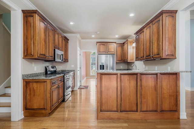 kitchen with light hardwood / wood-style flooring, light stone countertops, and appliances with stainless steel finishes