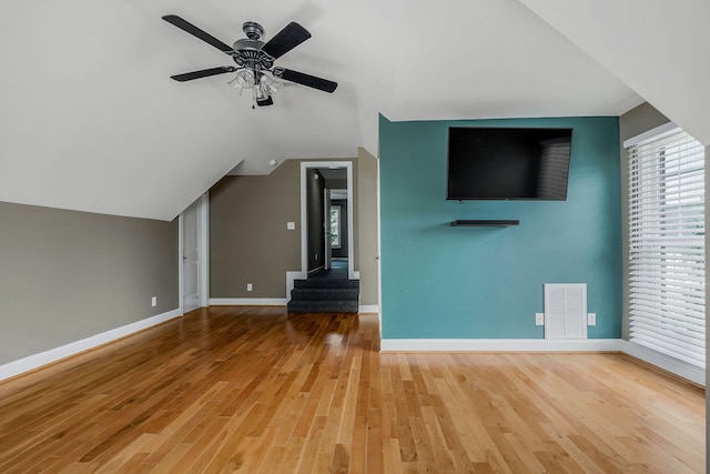 unfurnished living room featuring ceiling fan, vaulted ceiling, and light hardwood / wood-style flooring