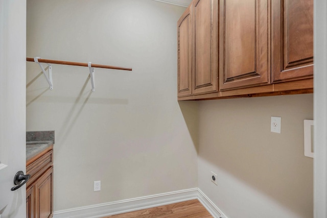 clothes washing area with cabinets, wood-type flooring, and hookup for an electric dryer