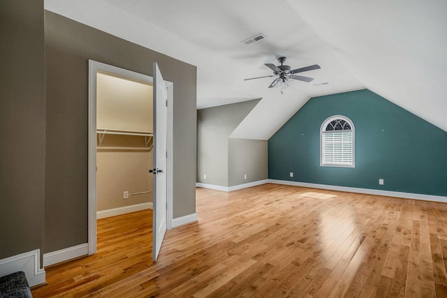 additional living space featuring lofted ceiling, ceiling fan, and light wood-type flooring