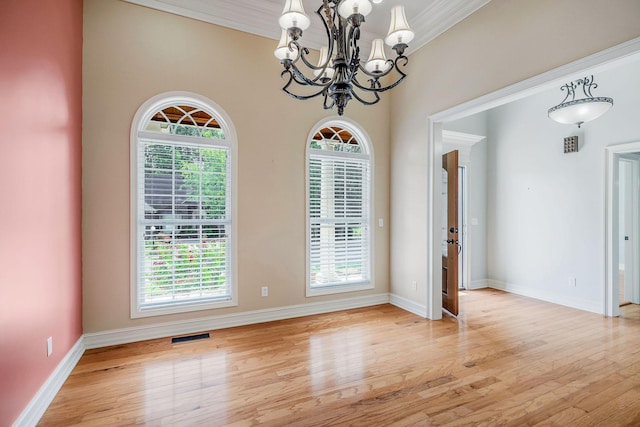 unfurnished dining area featuring crown molding, a notable chandelier, and light hardwood / wood-style floors