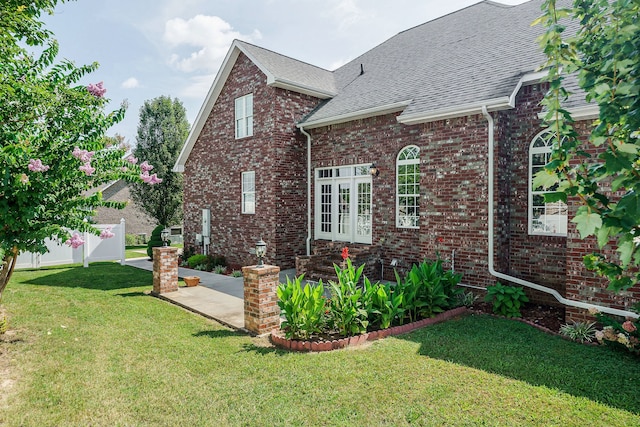 view of front facade with a patio area, french doors, and a front lawn