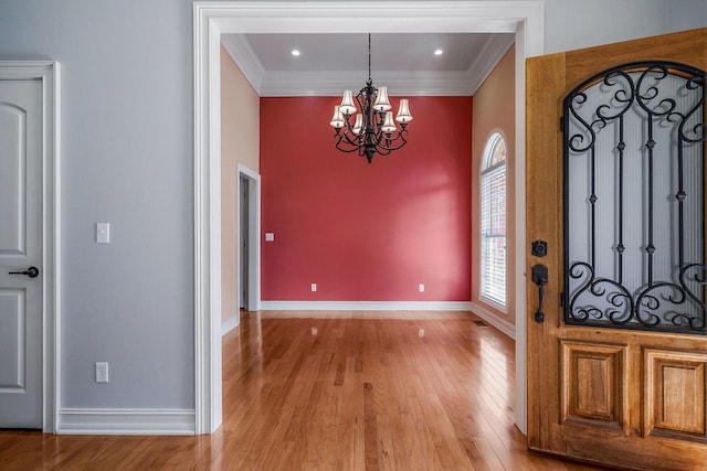 entryway with crown molding, a chandelier, and light hardwood / wood-style flooring