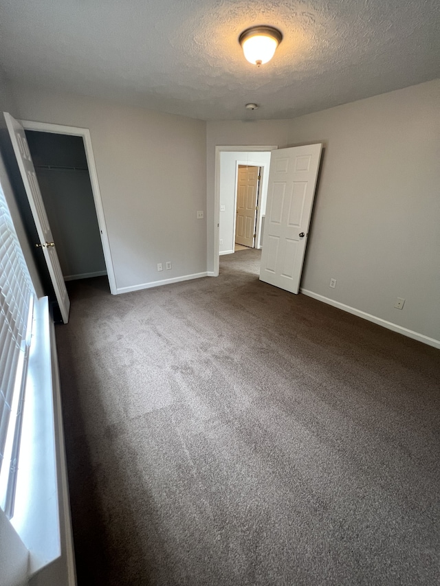 carpeted empty room with a textured ceiling