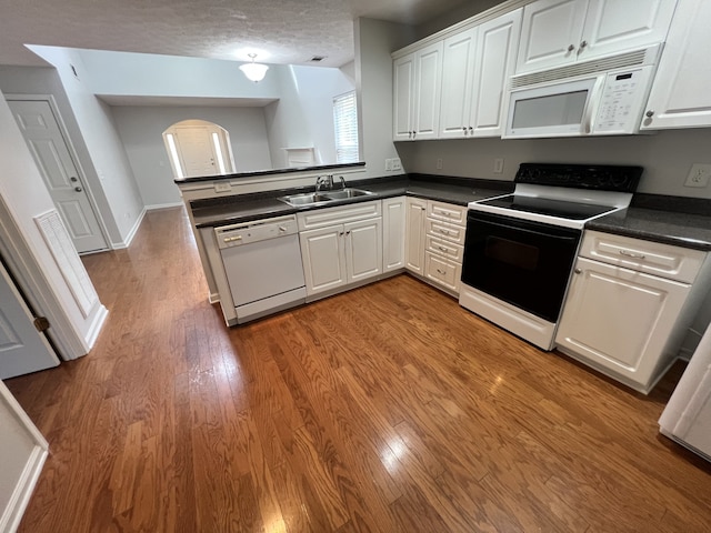 kitchen with white cabinetry, sink, and white appliances