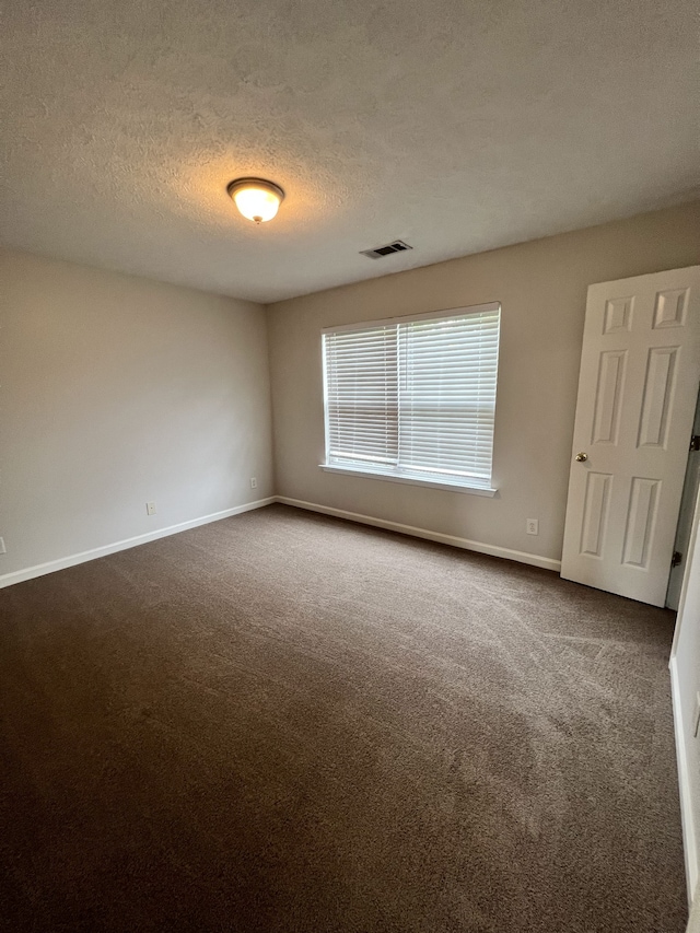 unfurnished room featuring carpet floors and a textured ceiling