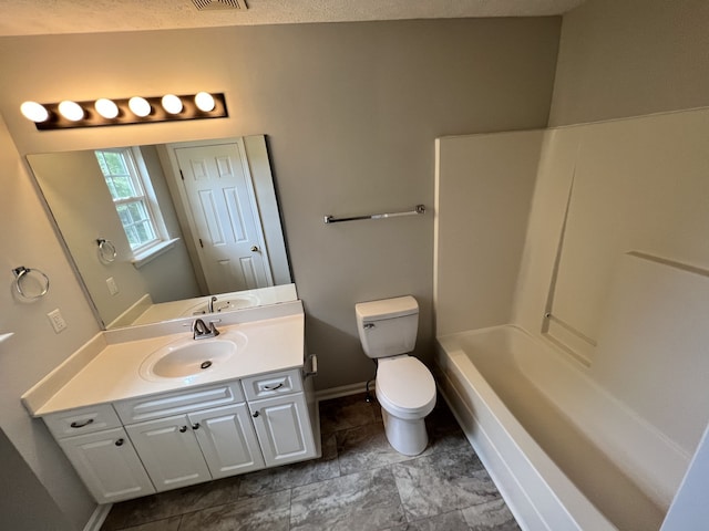 bathroom featuring toilet, a textured ceiling, and vanity