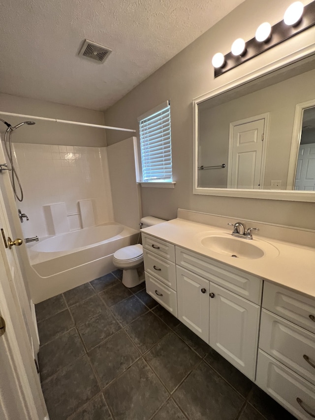 full bathroom with shower / washtub combination, a textured ceiling, toilet, tile patterned floors, and vanity