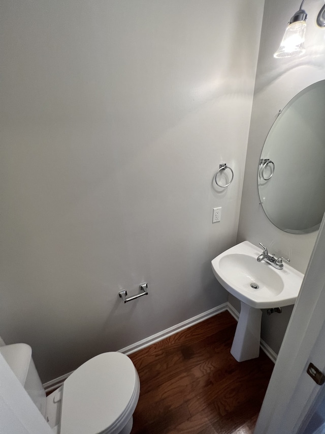 bathroom with hardwood / wood-style floors and toilet