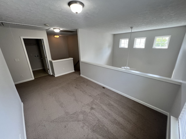 carpeted spare room with a textured ceiling