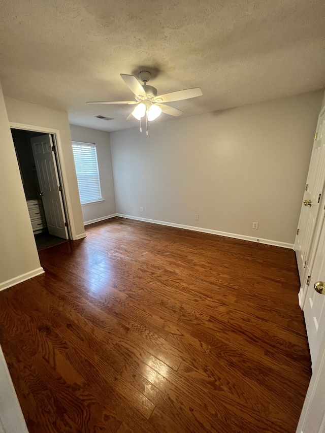 unfurnished bedroom featuring a textured ceiling, dark hardwood / wood-style floors, and ceiling fan