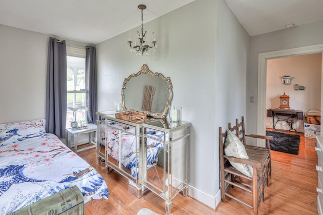 bedroom featuring light wood-style floors, baseboards, and an inviting chandelier