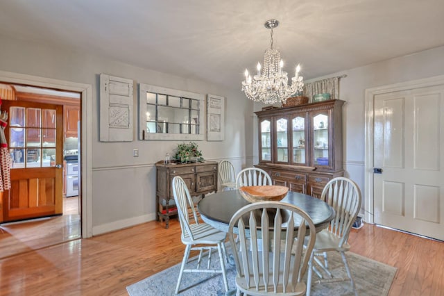 dining space with a chandelier and light wood-style floors