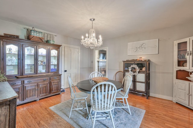 dining area featuring light wood-style floors and a chandelier