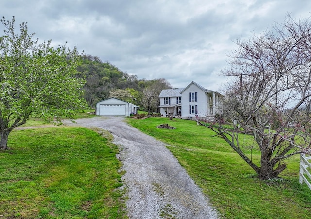 view of front of house featuring a garage, an outdoor structure, and a front lawn